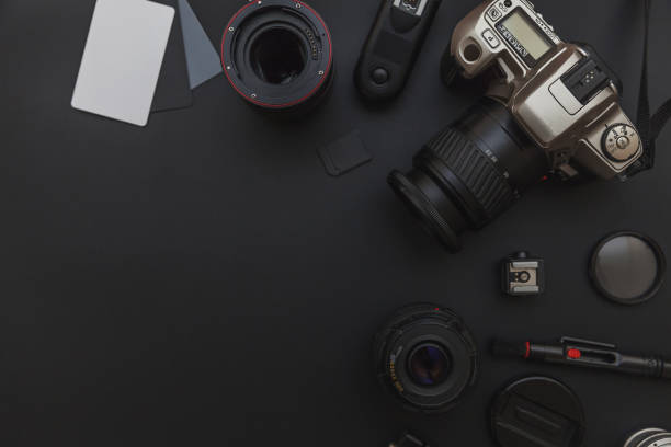 istock Photographer workplace with dslr camera system, camera cleaning kit, lens and camera accessory on dark black table background 1152487441