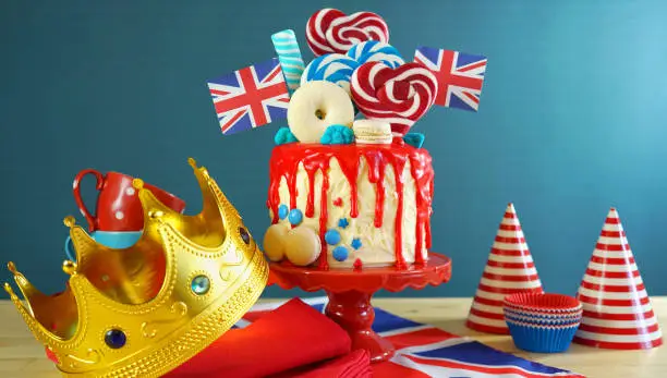 UK on-trend candyland fantasy drip cake with red, white and blue decorations, lollipops and flags.
