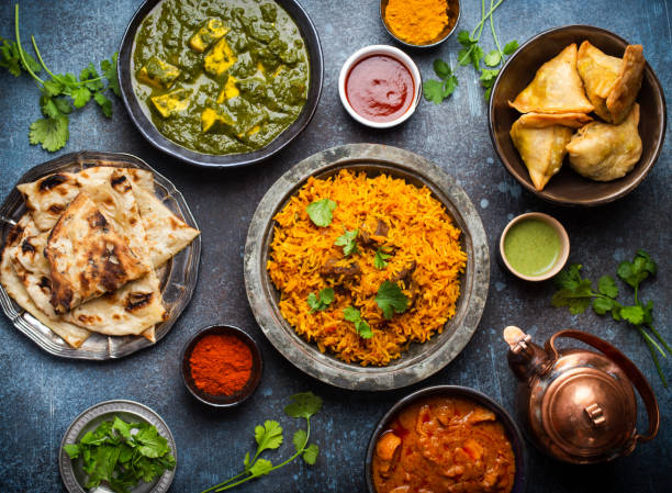 Authentic Indian dishes and snacks Top view of Indian traditional dishes and appetizers: chicken curry, pilaf, naan bread, samosas, paneer, chutney on rustic background. Table with choice of food of Indian cuisine, dinner/buffet bangladesh photos stock pictures, royalty-free photos & images