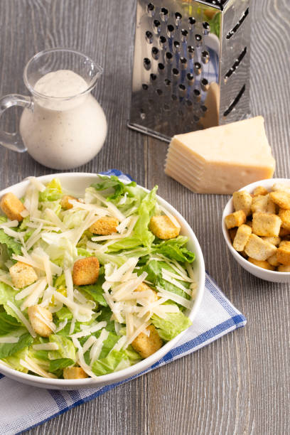 istock Fresh Caesar Salad on a Wooden Kitchen Table 1152496801