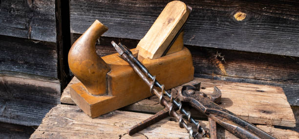 istock Antique hand tools plane pincers and drills. Old brown boards. Copy space, panoramic photo. 1152499846