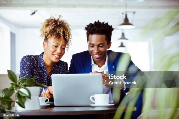 Smiling White Collar Workers Looking At Laptop Stock Photo - Download Image Now - Financial Planning, Happiness, 30-34 Years