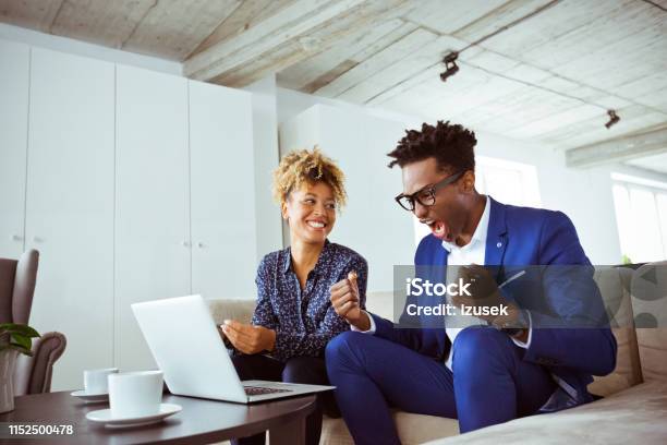 Businesswoman Looking At Happy Colleague In Office Stock Photo - Download Image Now - Businessman, Celebration, Excitement