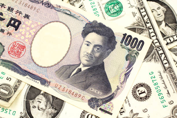 A Japanese yen bank note with American one dollar bills stock photo