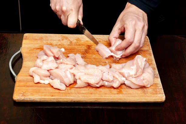 istock cutting fresh raw chicken. man prepare chicken on wooden board. 1152502576