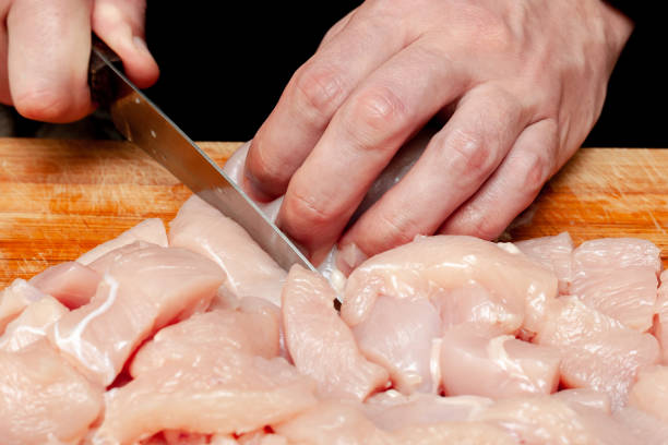 istock cutting fresh raw chicken. man prepare chicken on wooden board. 1152502589