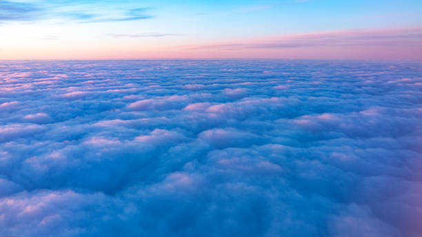 Beautiful pink sunrise over the clouds, view from the plane.
