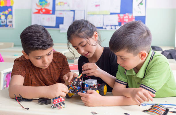 groupe d’étudiants turcs développent le robot dans le classrom - young team photos et images de collection