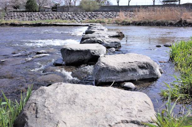 istock Crossing the river while feeling the rocks, adventure and challenging 1152503754