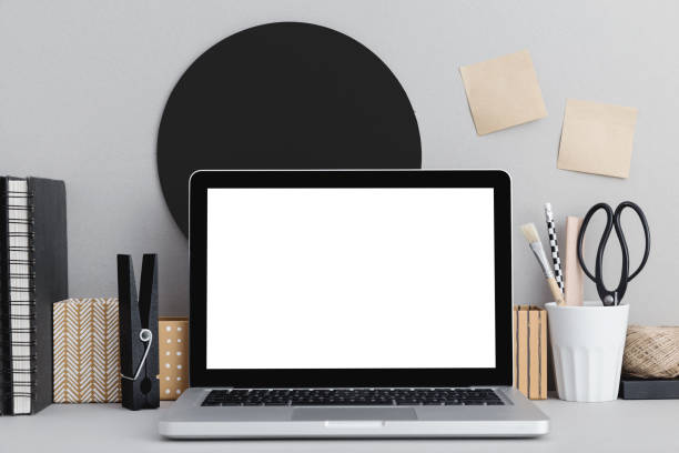 istock Stylish workspace with laptop mock up, office supplies, and sticky notes on grey wall. 1152511916