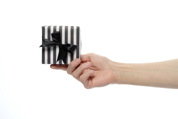 istock Male hand giving a box with a present on a white isolated background. 1152512103