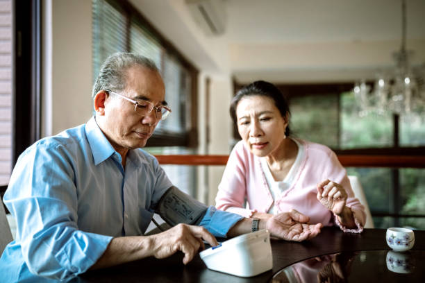 senior couple measuring blood pressure - common serious couple men imagens e fotografias de stock