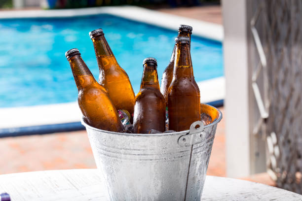 istock Bucket with ice cold beer with pool behind 1152517106