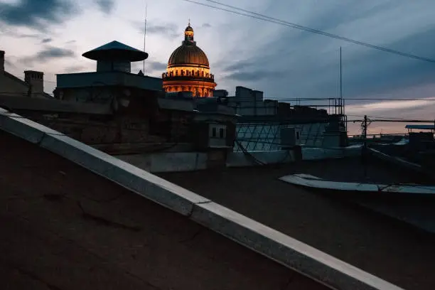 St. Isaac's Cathedral illuminated in St. Petersburg, view from the roof of the city at sunset.