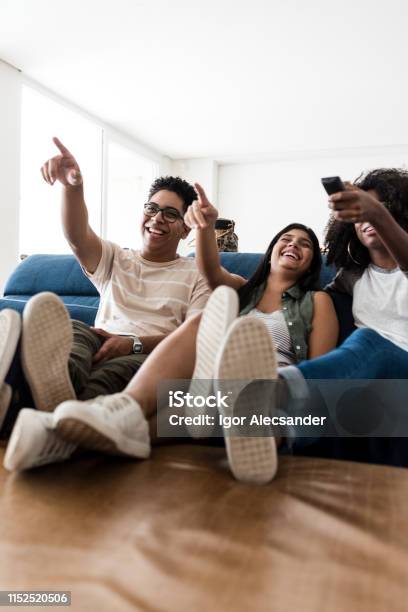 Foto de Adolescentes Que Sentamse No Sofá Que Escolhe O Filme Junto e mais fotos de stock de Assistir TV