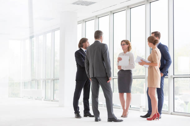 istock Business colleagues discussing while standing against window in new office 1152522084