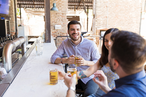 Happy man enjoying beer with friends at restaurant