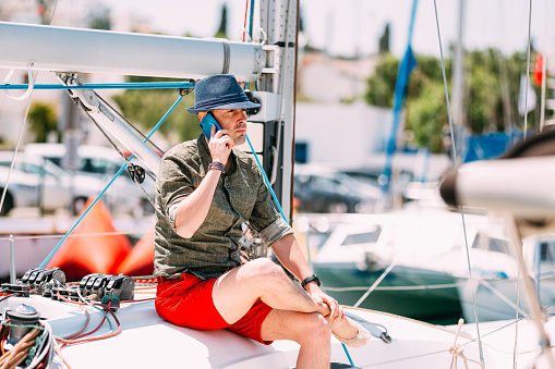 Young Man Talking by Phone on Yacht
