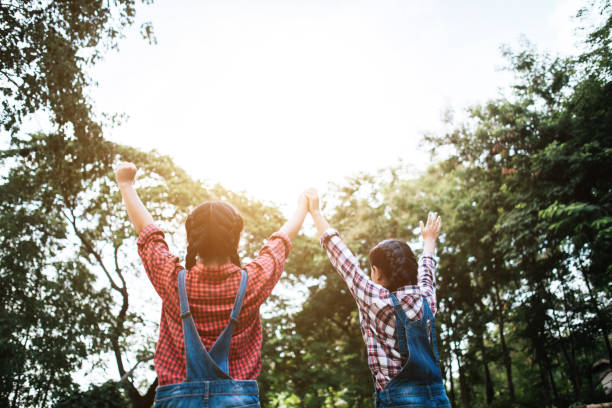 istock Two girl friends holding hands and held up. 1152532700