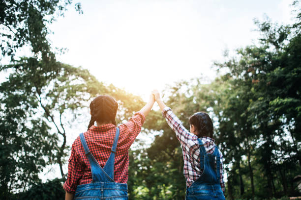 istock Two girl friends holding hands and held up. 1152532713