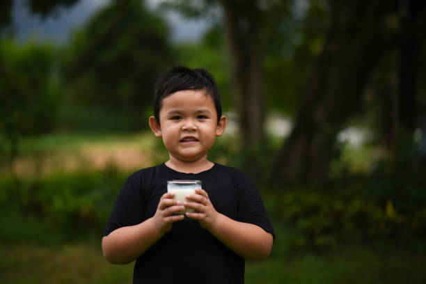 Little boy drinking milk in the park