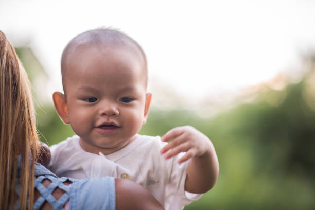 istock Mother throws baby up, laughing and playing in the park 1152533743