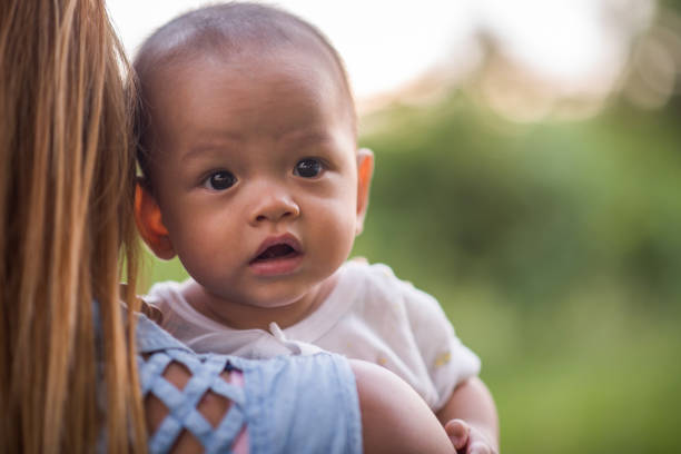 istock Mother throws baby up, laughing and playing in the park 1152533757