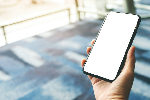 istock a woman's hands holding and using black mobile phone with blank screen while sitting in the airport 1152533833