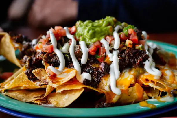 Beef and cheese corn nachos served on a big plate ready to eat - Image