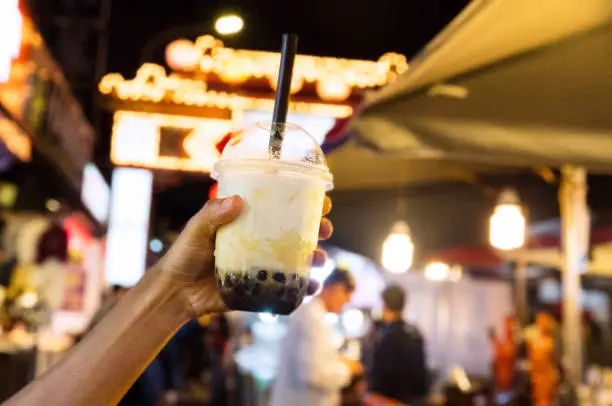 Hand holding cup with bubble milk at the night market- Taipei, Taiwan