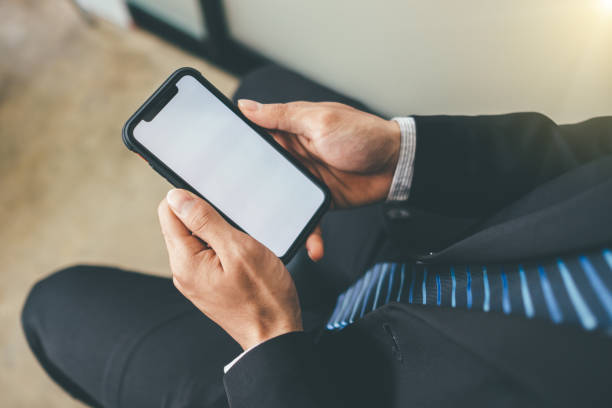 istock businessman sitting in at wooden table, using smartphone.On table is laptop. internet, chatting, blogging. man holding phone and looking 1152540133