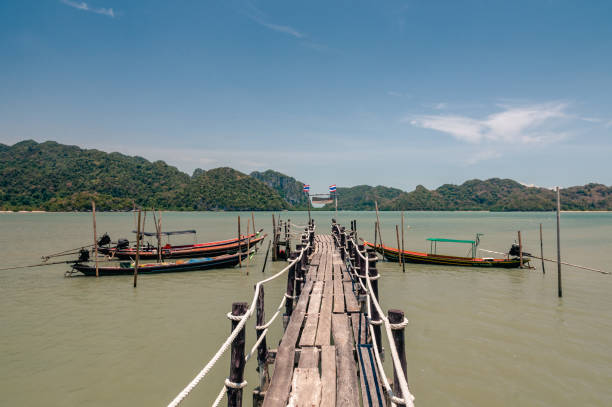 istock Wooden pier and thai long tail boats. 1152542087