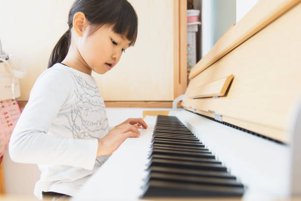 istock Girl playing piano at home 1152545477