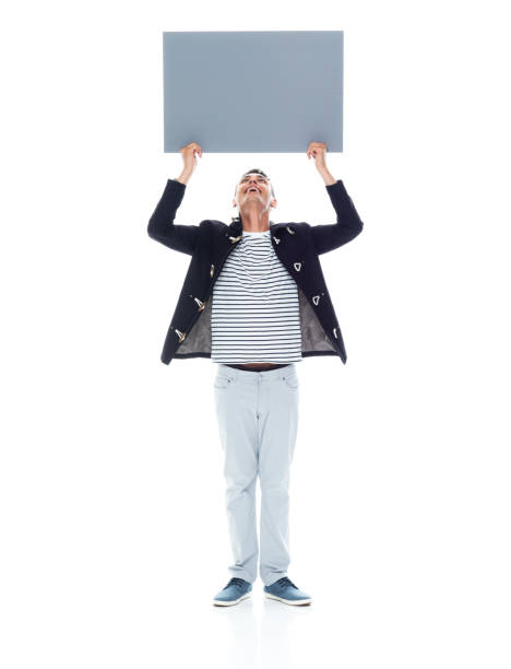 istock Handsome black man wearing a jacket and grey pants - holding placard above head 1152547771