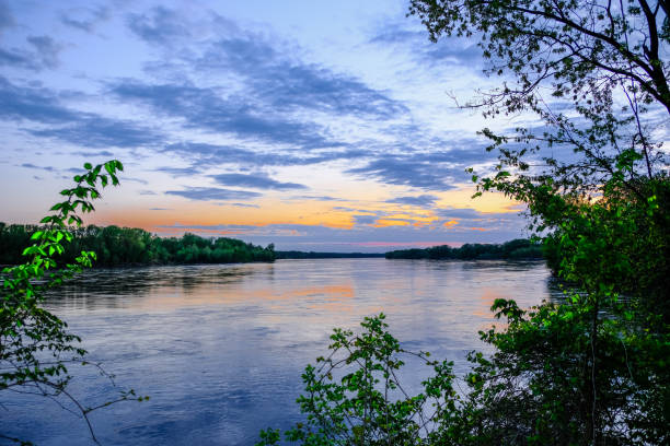 Sunset on Missouri River in spring; cloudy dark blue sky