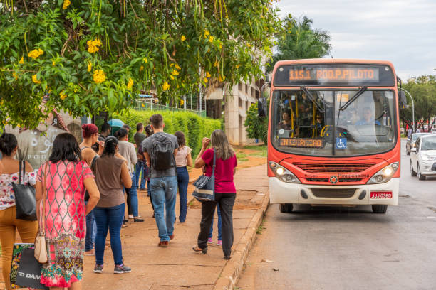 People waiting at bus stop in Brasilia city centre with a bus approaching