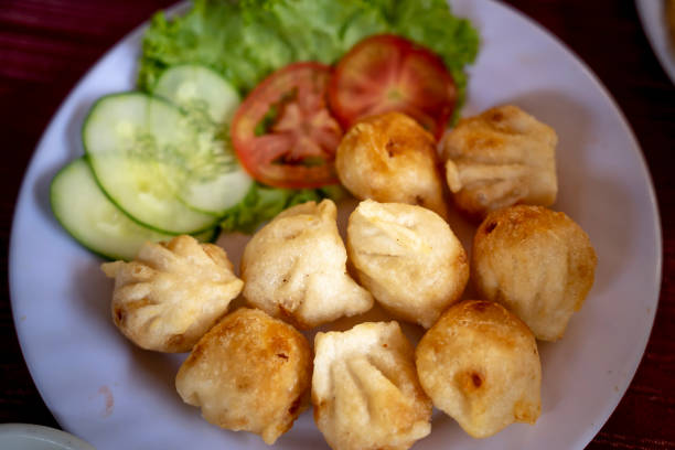 istock Fried dumplings stuffed with meat and served with chopped parsley and spring onion. 1152552010