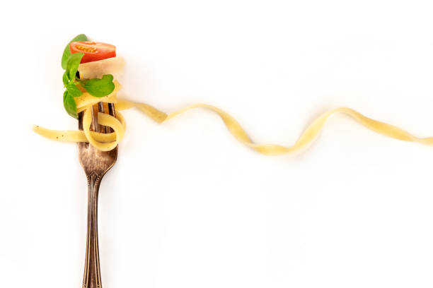 istock Italian pasta. A fork with a very long pappardelle, basil, cheese, tomato, and pepper, on a white background with a place for text 1152553613