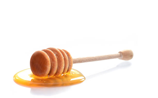 istock Honey dipper with liquid yellow honey isolated on white 1152554574