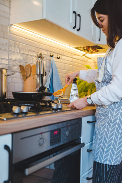 istock woman fry on pan kitchen view 1152554714