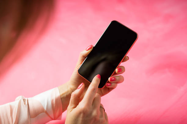 Unrecognisable Caucasian ethnicity female using mobile phone and touching screen with finger