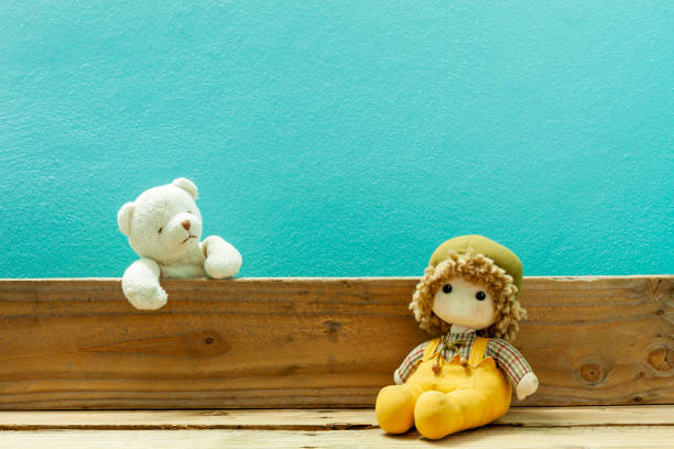 Old toy and Teddy bear on old wood in front blue background.