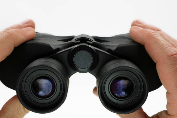 istock close up, front view of hands holding black binoculars on white background 1152558350