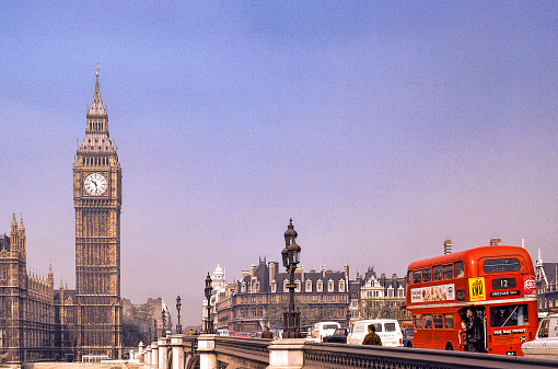 Nostalgi. Big Ben and double decker., London 1973.. \nThe red double decker is passing over a bridge towards Houses of parliament and Big Ben in the background. More cars nd pedestriana on the bridgege. Clear sky with some haze.\n\n+++ scanned slide from 1973 +++