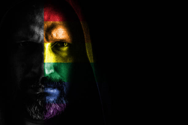 istock Brutal man with a gray beard in the hood with sharp shadows on a black background. Copy space. 1152563340