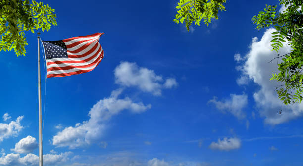 Dyanmic photo of 3 flags including the United States of America USA flag blowing in the wind