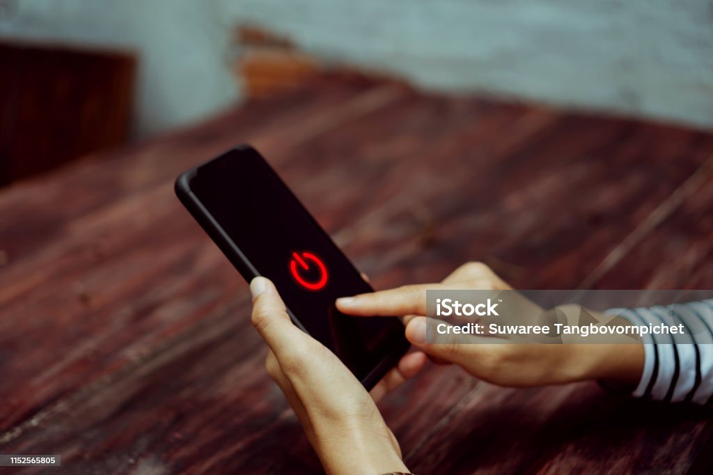Woman hand using smartphone to switch off or shut down online and social connection. Business, financial, trade stock maket and social network concept. Turning On Or Off Stock Photo