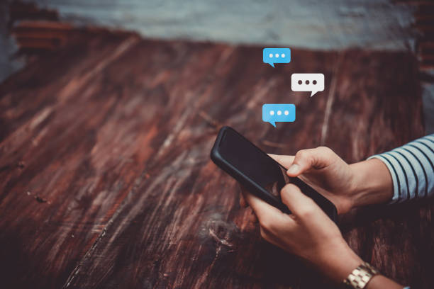 istock Women hand using smartphone typing, chatting conversation in chat box icons pop up. Social media maketing technology concept.Vintage soft color tone background. 1152565815