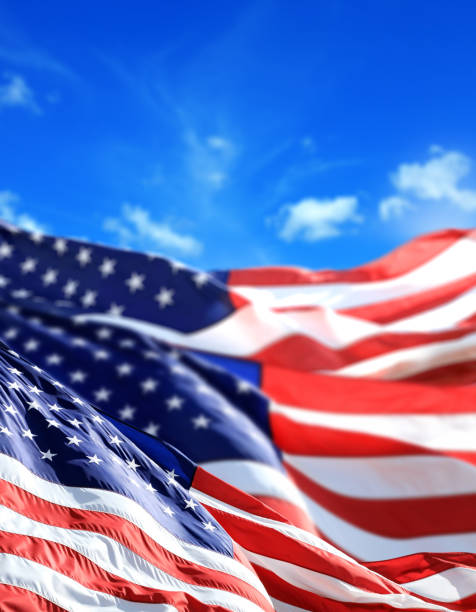 istock close up waving American flags over sunny cloudy blue sky 1152566358