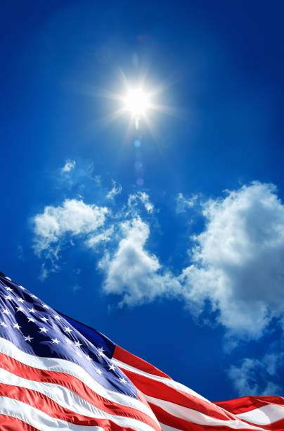 istock close up waving American flag over sunny cloudy blue sky 1152566489